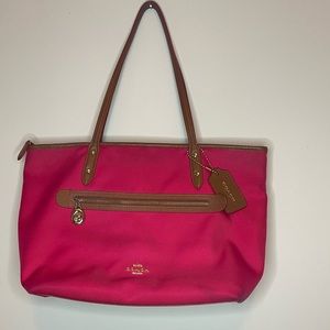 Coach purse with red lining. Outside of bag is a fuchsia color